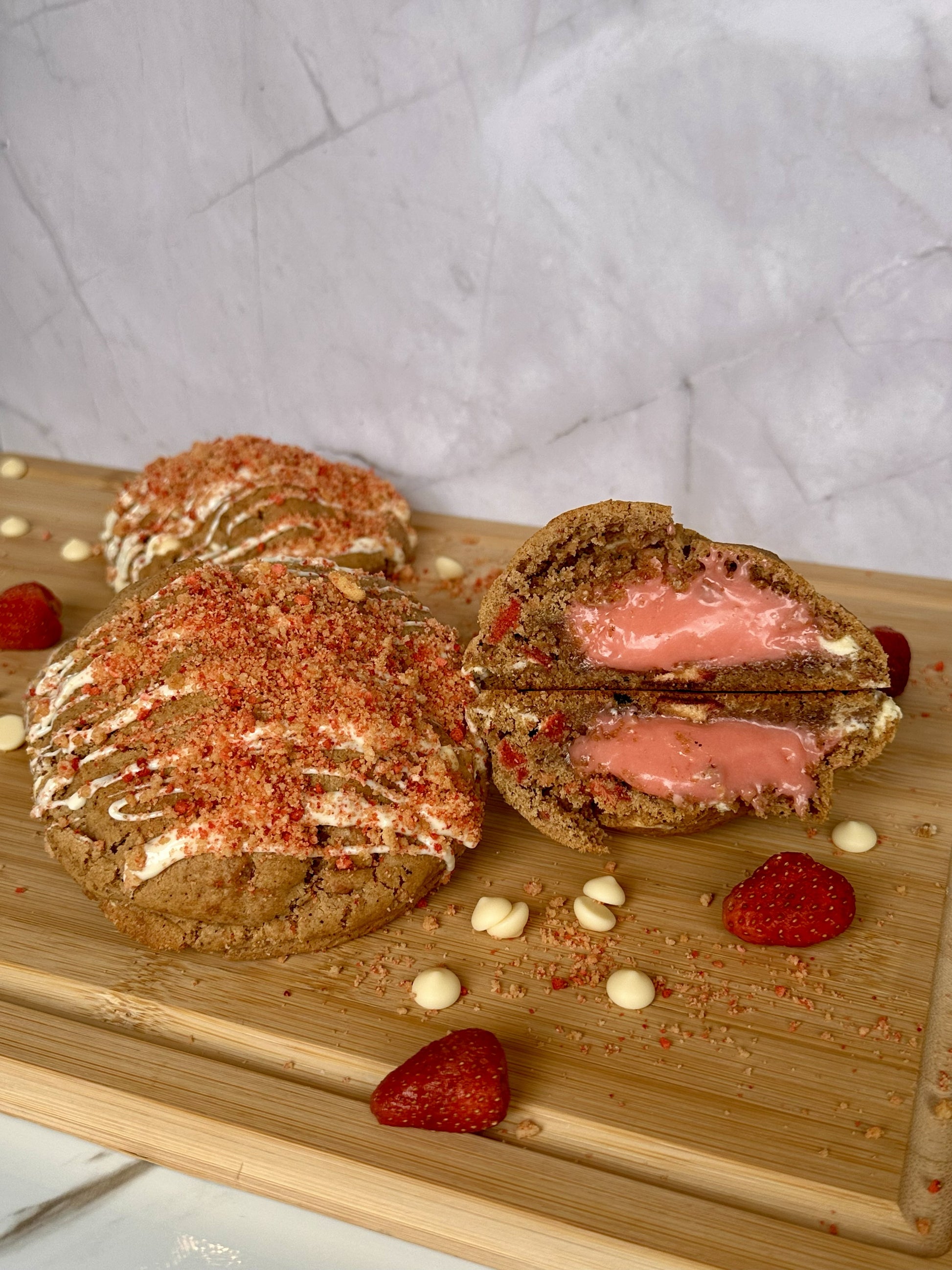 Shortcake Shawty - Strawberry Shortcake Cookie with pink praline filling, white chocolate drizzle, and strawberry crunch topping by Sinful Bites Las Vegas